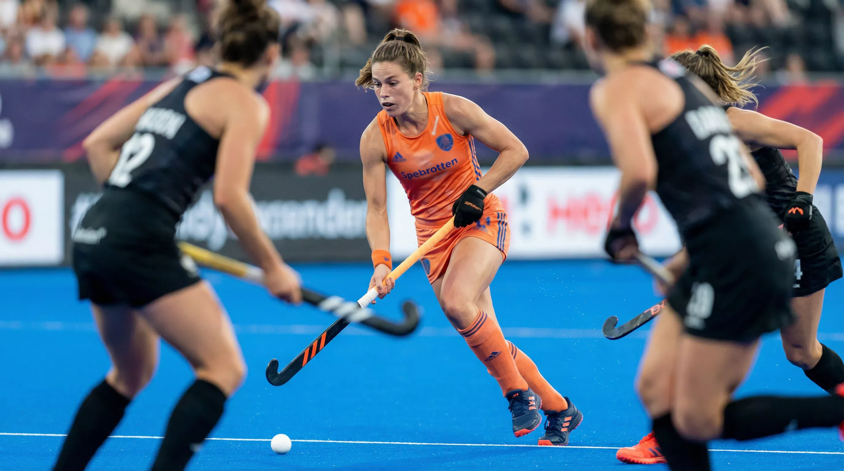 Middenveldster in actie met kenmerkende versnelling op het hockeyveld