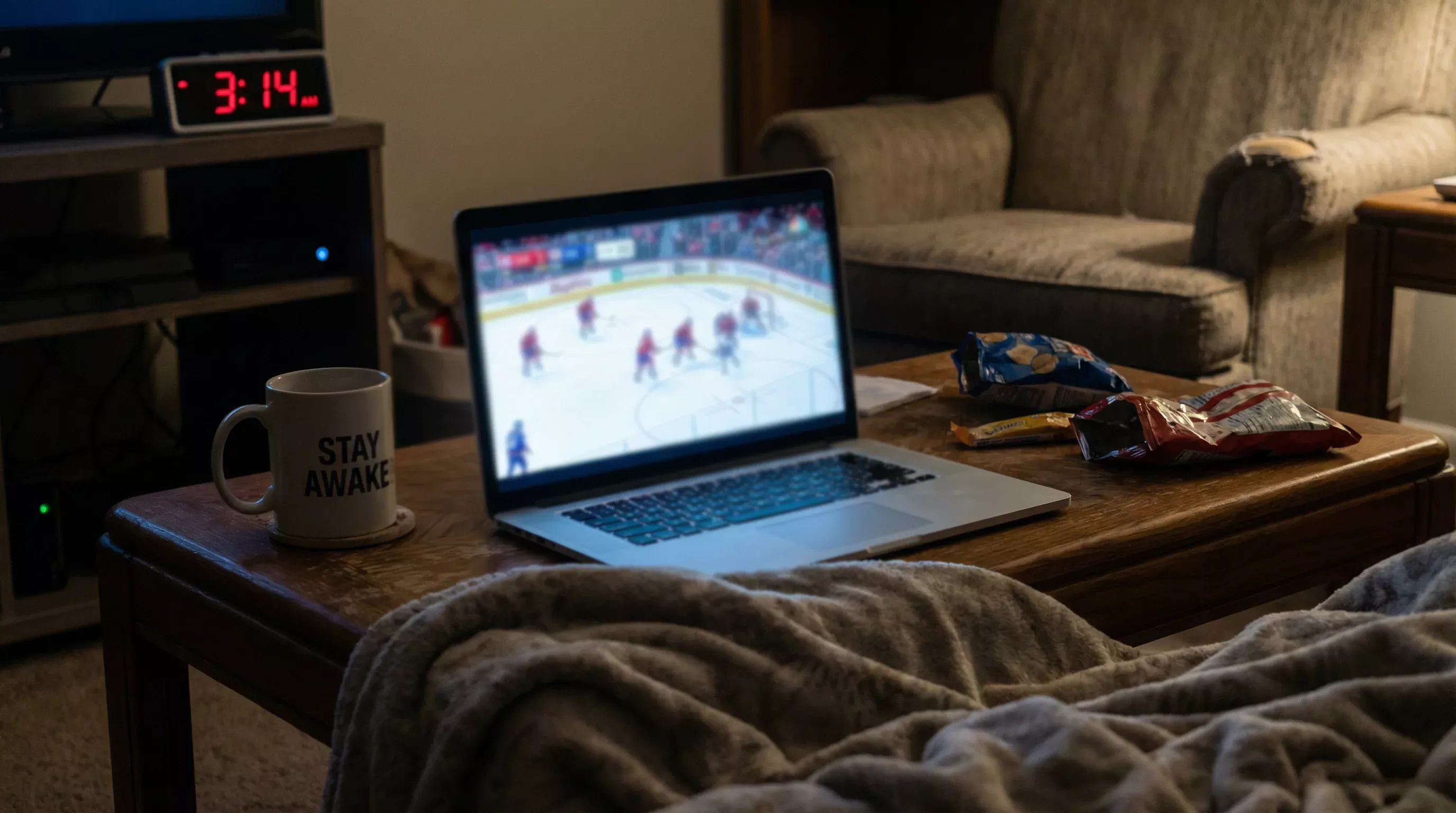 Nachtelijke sportweddenschap sessie met laptop en hockeywedstrijd