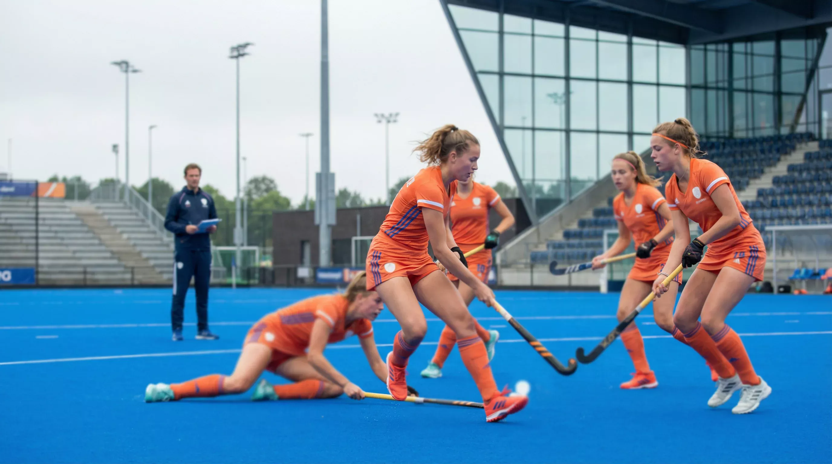 Jonge hockeysters tijdens intensieve training op kunstgras